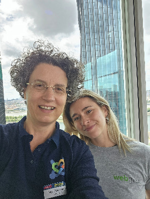Sigrid und Pia stehen vor einem Fenster im 19. Stock mit Ausblick über Wien.